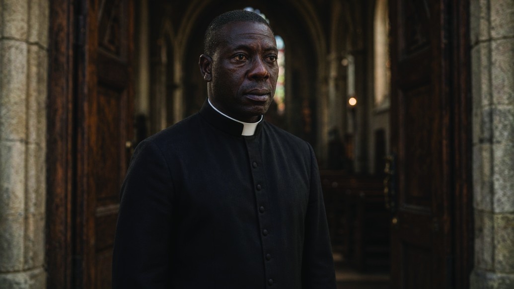 Medium: Peter in clerical collar in a church doorway
